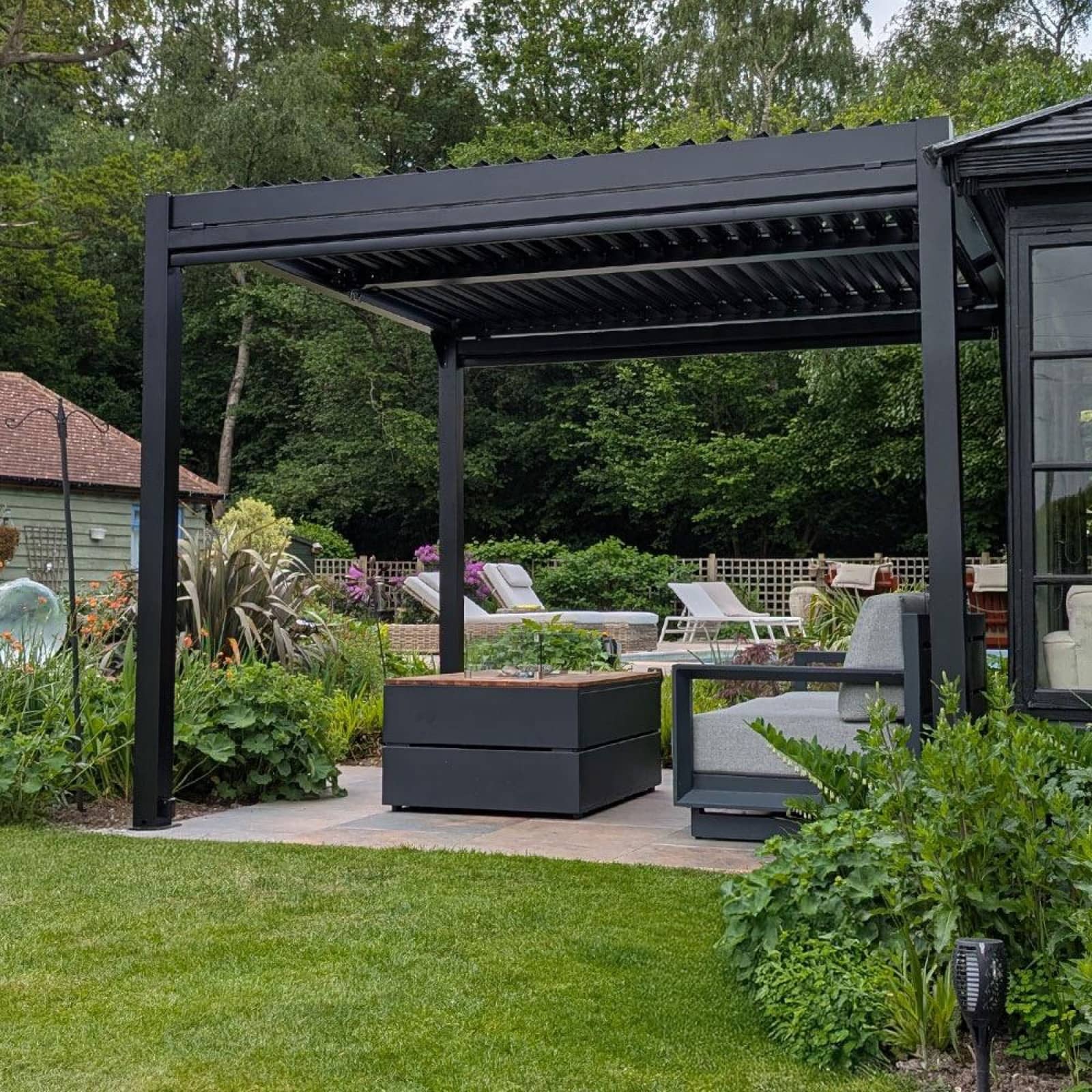 Large black aluminium pergola in a private garden terrace